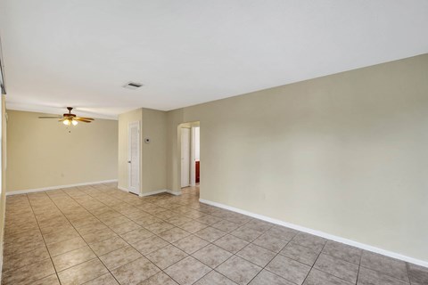 A room with a ceiling fan and tile flooring.