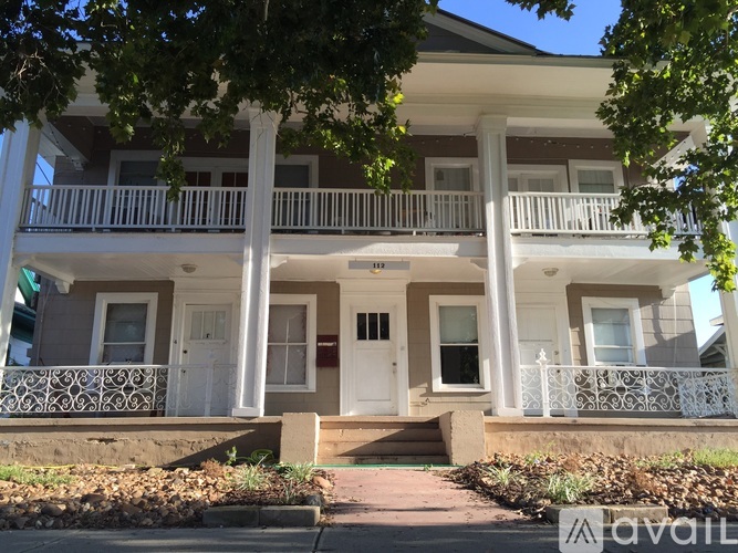 A two-story house with a white front door and a balcony.