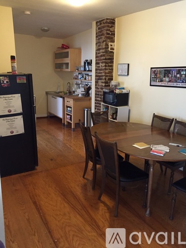 A kitchen with a refrigerator and a dining table.