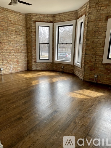 A room with wooden floors and brick walls.