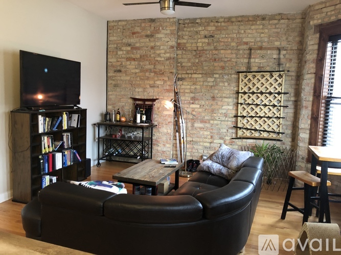 A living room with a brick wall and a television.