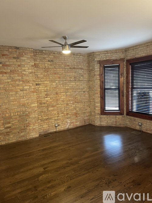 A room with a brick wall and wooden flooring.