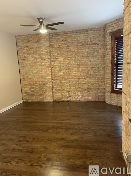 A room with a brick wall and wooden floor.