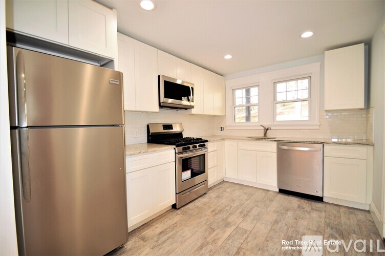 A kitchen with a stainless steel refrigerator, microwave, oven, and dishwasher.
