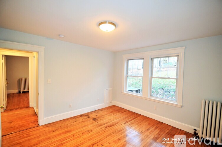 A room with a wooden floor and a window.