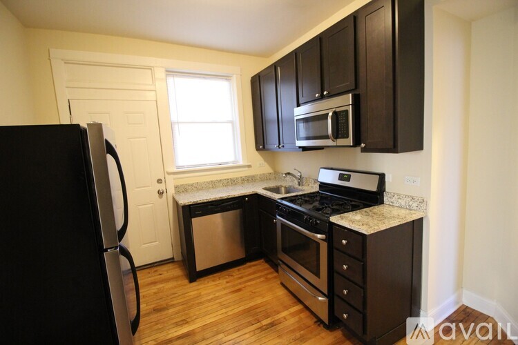 A kitchen with black cabinets and stainless steel appliances.