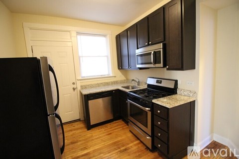 A kitchen with black cabinets and stainless steel appliances.