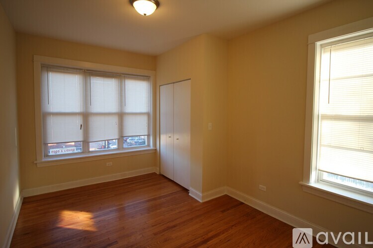 A room with a window and a wooden floor.