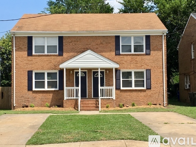 A brick house with a porch and a white awning.