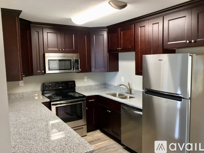 A kitchen with dark wood cabinets and stainless steel appliances.