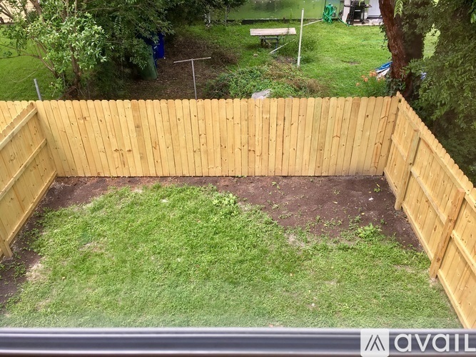 A wooden fence encloses a grassy area.