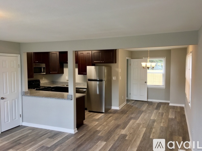 A kitchen with dark brown cabinets and a stainless steel refrigerator.