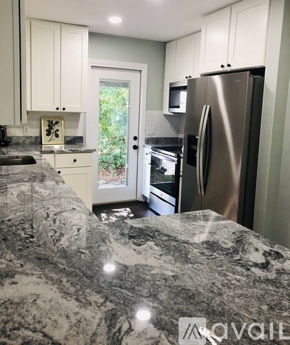 A kitchen with a marble countertop and stainless steel appliances.