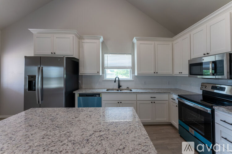 A kitchen with a granite countertop and stainless steel appliances.