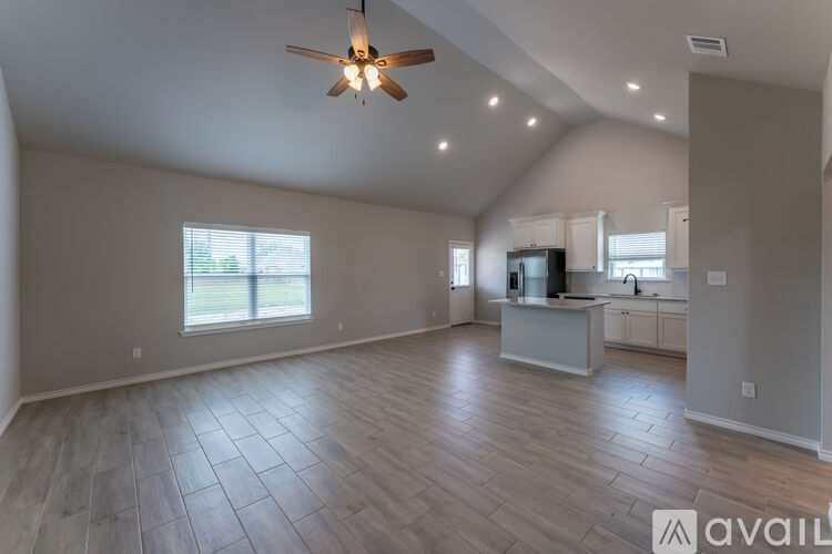 A spacious room with a ceiling fan and lighting fixtures.
