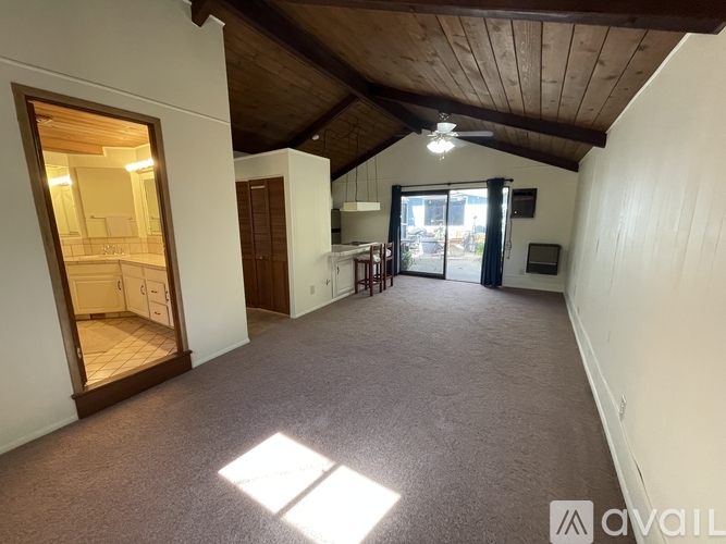 A room with a carpeted floor and a wooden ceiling.