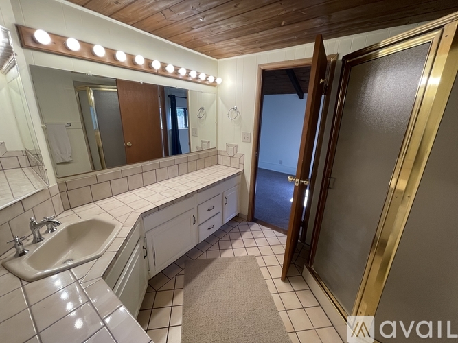 A bathroom with a sink, mirror, and tiled floor.