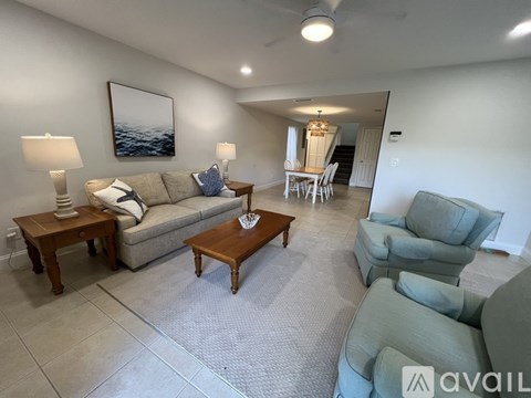 A living room with a grey couch, a wooden coffee table, and a painting on the wall.