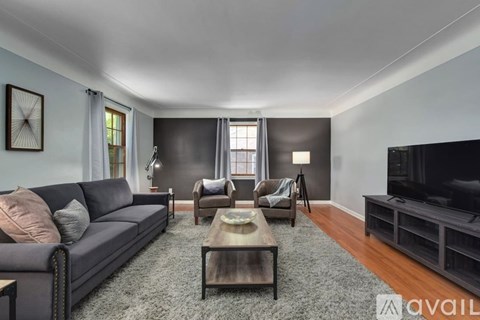 A living room with a grey couch, a coffee table, and a television.