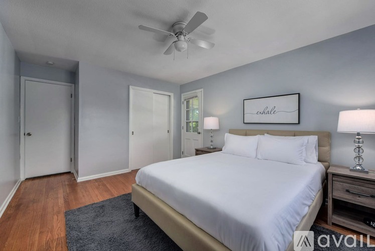 A bedroom with a bed, nightstand, and a ceiling fan.