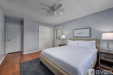 A bedroom with a bed, nightstand, and a ceiling fan.