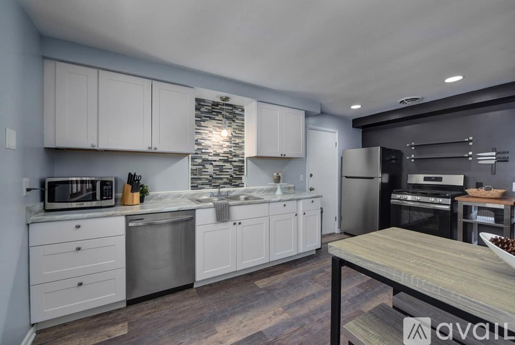 A kitchen with white cabinets and a wooden table.