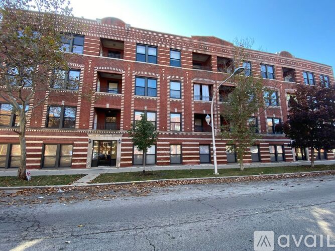A red brick building with a street in front of it.