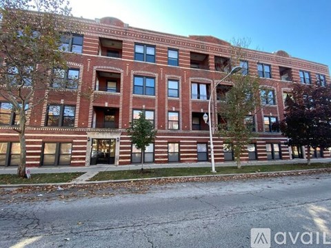 A red brick building with a street in front of it.