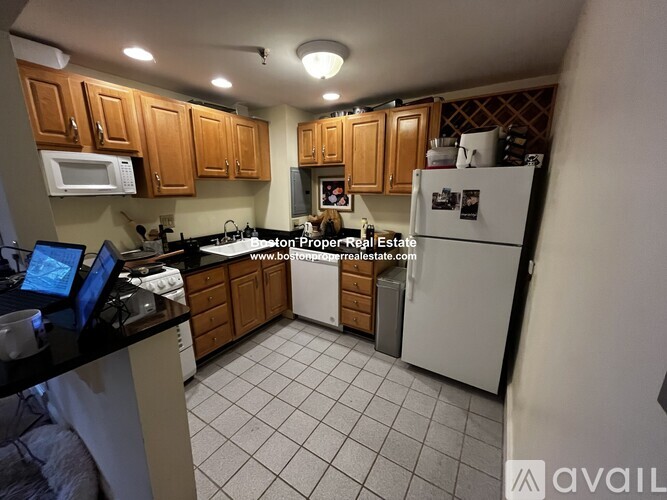 A kitchen with a white fridge and wooden cabinets.