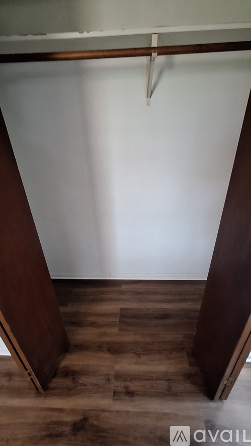 A room with a white wall and a wooden floor.