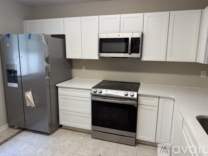 A kitchen with white cabinets and a black stove top oven.