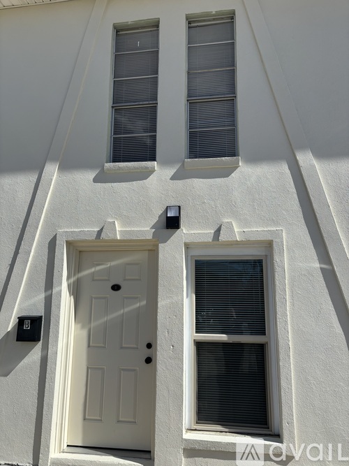 A white door with a window above it and a window to the right of the door.