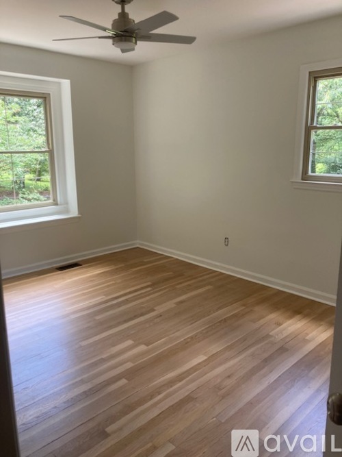 A room with wooden flooring and a ceiling fan.
