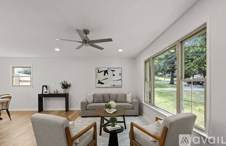 A living room with a grey couch, a coffee table, and a ceiling fan.