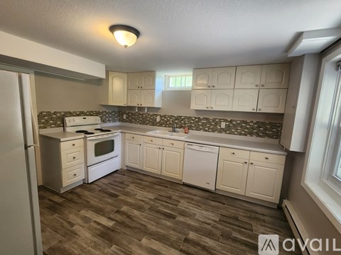 A kitchen with white cabinets and a tiled backsplash.