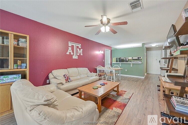 A living room with a couch, chair, and a ceiling fan.