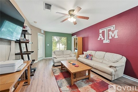 A living room with a white couch and a ceiling fan.