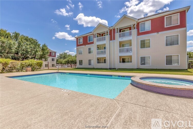 A large apartment complex with a pool in the foreground.