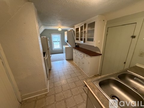 A kitchen with white cabinets and a tiled floor.