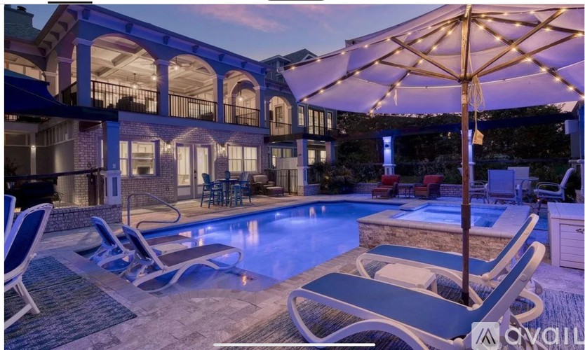 A poolside area with lounge chairs and a canopy.