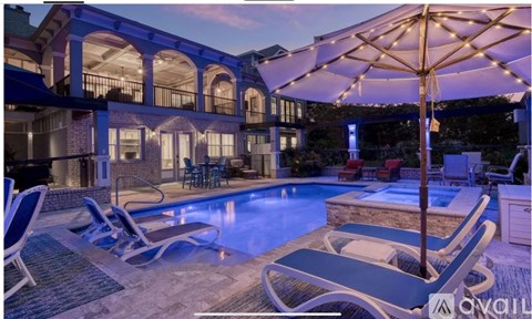 A poolside area with lounge chairs and a canopy.