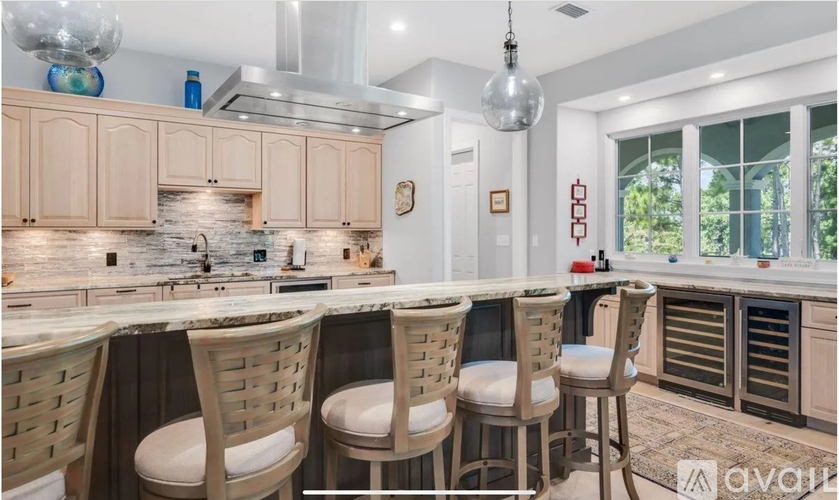 A kitchen with wooden chairs and a marble countertop.