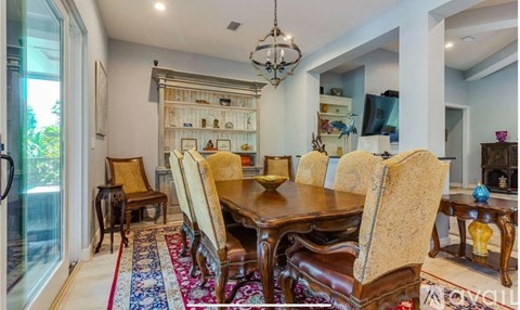 A dining room with a large table and chairs.