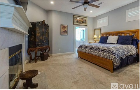 A bedroom with a large bed and a fireplace.