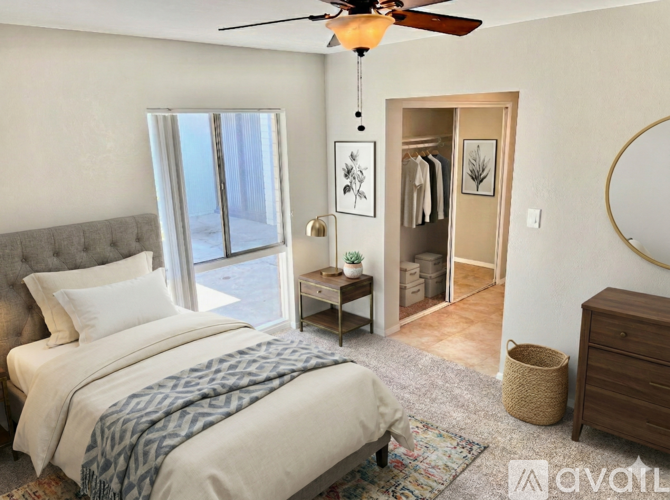 A bedroom with a large bed and a ceiling fan.