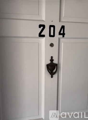 A white door with a black handle and a number 204 on it.