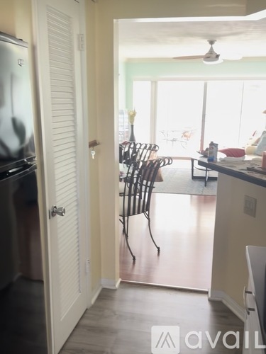 A kitchen with a table and chairs in the background.