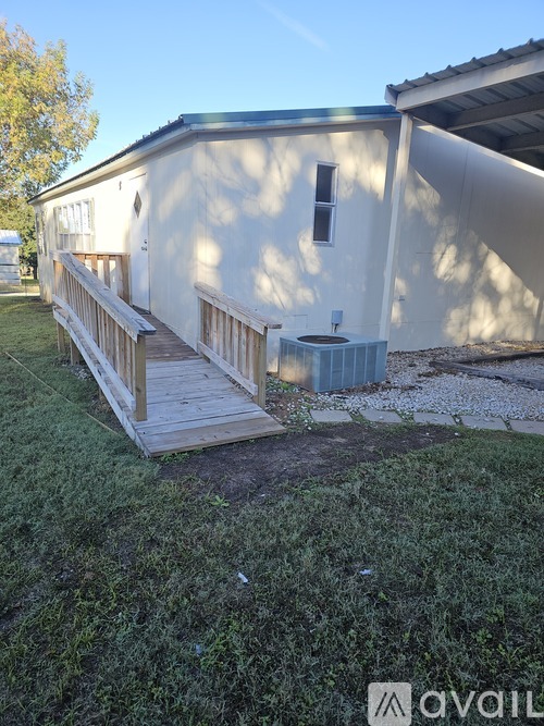 A white building with a wooden deck in front.