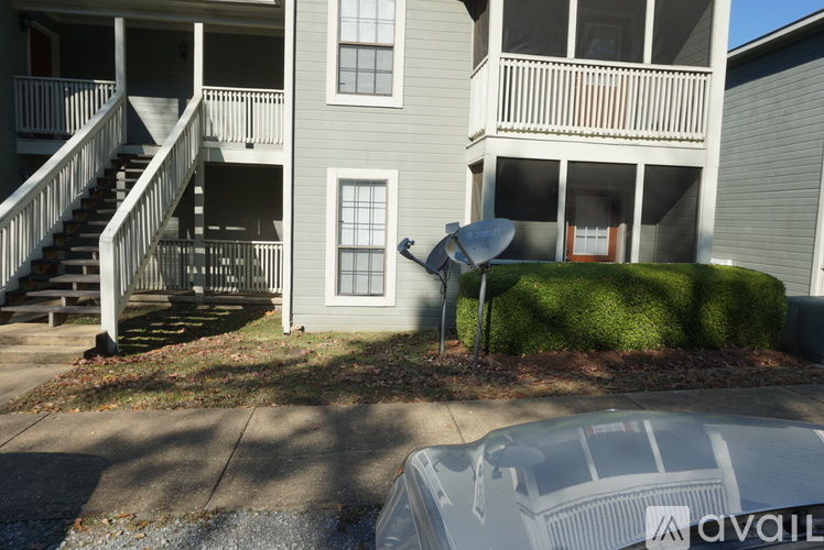 A car is parked in front of a building with a sign that says "available".