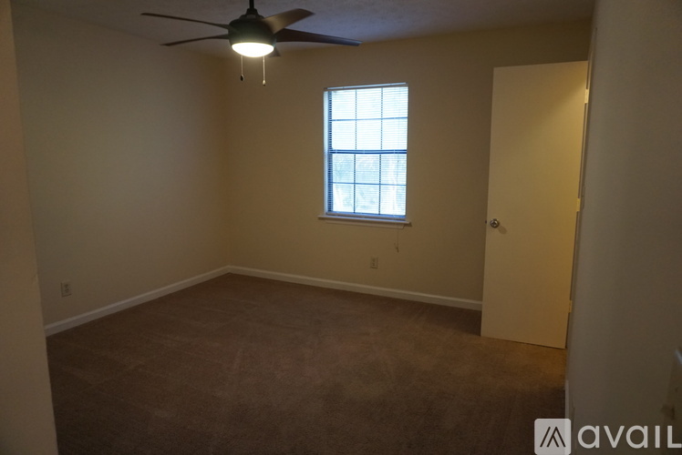 A room with a ceiling fan and a window.